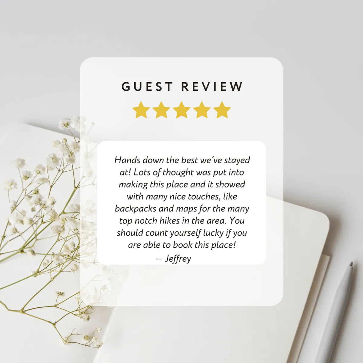 The image displays a guest review, a bouquet of flowers, a notebook, and a pen set on a table. This composition conveys thoughtful planning and pleasant reflections, evoking the idea of guests mapping out new hikes or reminiscing on the day’s experiences.